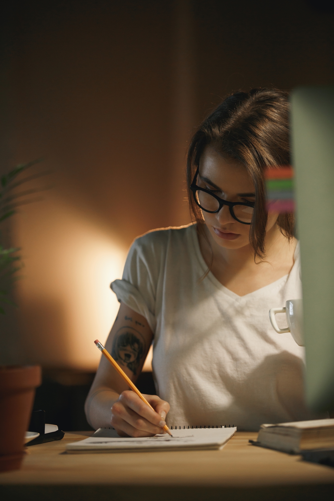 Mujer diseñadora escribiendo notas por la noche